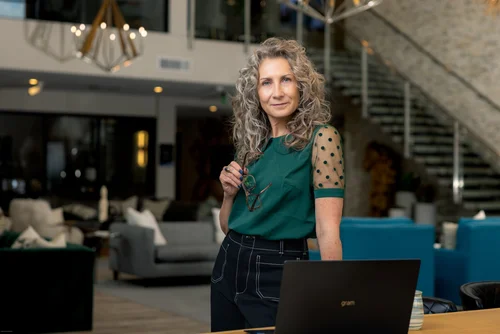 Christine working on a laptop in a modern lobby