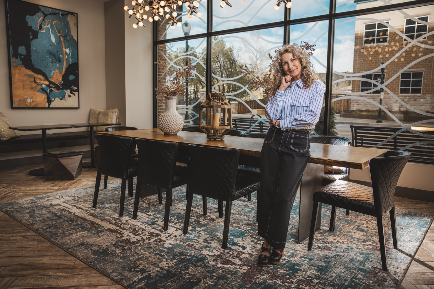 Christine leaning on a conference table in a modern office