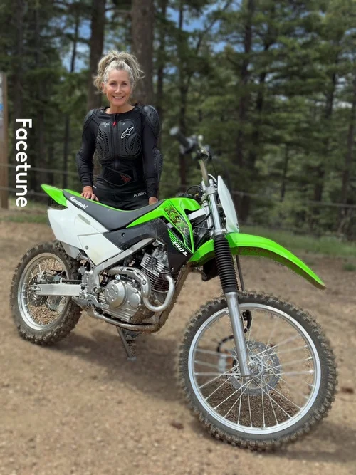 Christine with a dirt bike in the mountains
